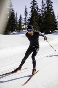 Langlauf - Mann skatet auf Langlaufskiern auf Loipe